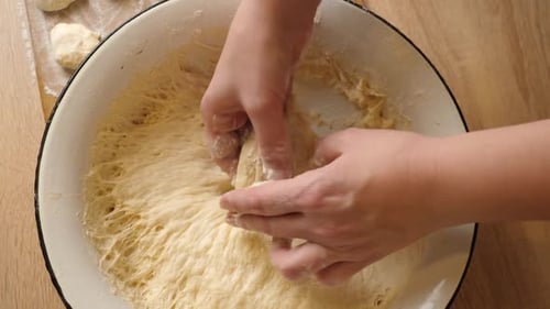 06sm. A woman forms pieces of dough for making donuts. The process of making donuts. Slow motion.