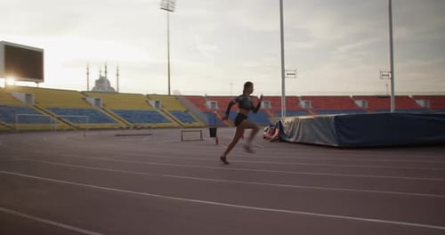 Athletic Woman Running on Stadium Track During Daytime