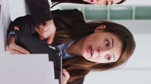 Vertical Video Specialists Taking Notes on Tablet After Reviewing Building Model