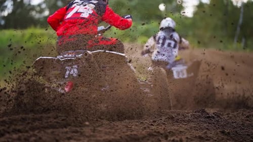 Quad Bikers Racing Competition on Dirt Muddy Road With Mud Scattering Under Wheels in Slow motion