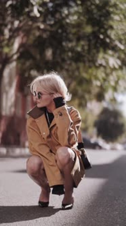 A beautiful professional model in a yellow jacket poses for the camera. Autumn fashion. The trend.