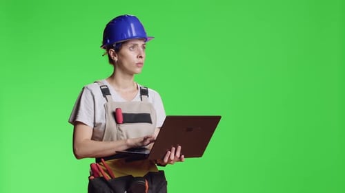 Female Construction Worker Browsing Internet on Laptop