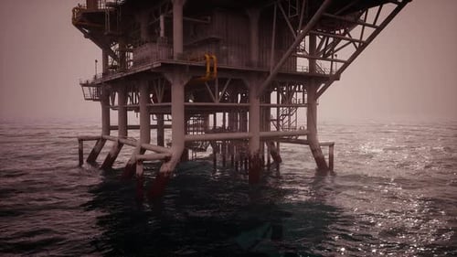 Detailed View of an Oil Rig Standing Tall in Calm Ocean Waters During Dusk