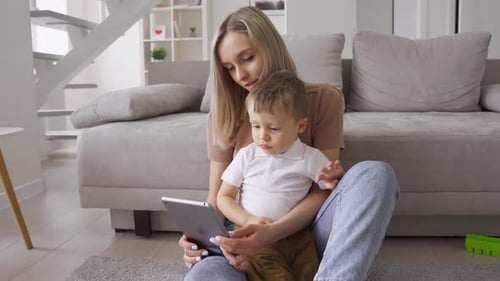 Woman and Child Enjoying Tablet Time on Floor