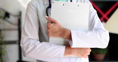 Primer plano del médico que sostiene el portapapeles y los registros médicos de un paciente
