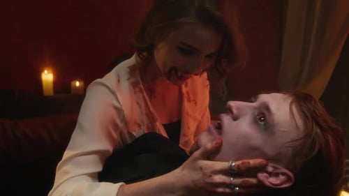 Vampire Woman Leaning Over her Newborn Vampire Lover in Flickering Candlelight