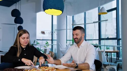 Colleagues having lunch at office. Working team want to have pizza sitting at big table.