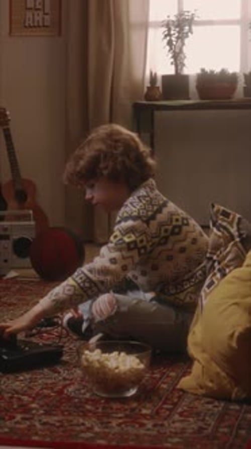 Vertical of Millennial Boy Starting Playing Console Video Game in 90s