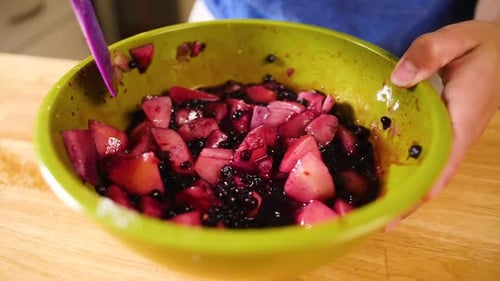 close up mixing fruit for pie filling