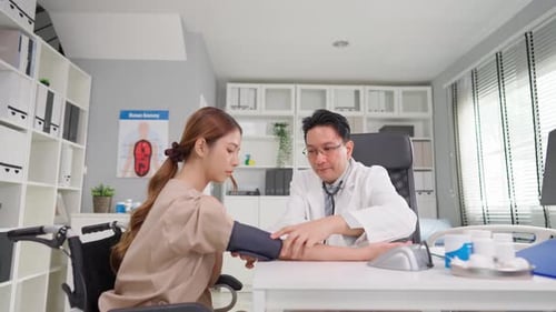 Asian doctor examine patient woman use blood pressure gauge in hospital.