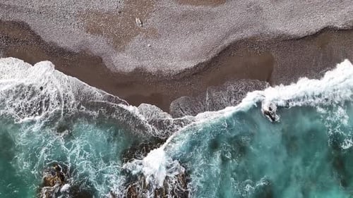 Top-down aerial shot of a volcanic beach on Sicily, Italy