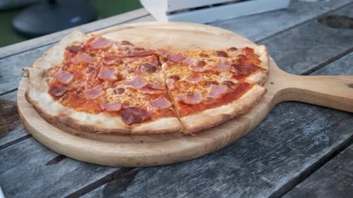 Frauenhände pflücken Pizza.