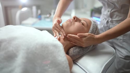 Woman Receiving Relaxing Facial Massage at Spa