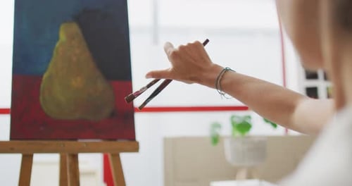 Artist paints a vibrant still life at home, with copy space