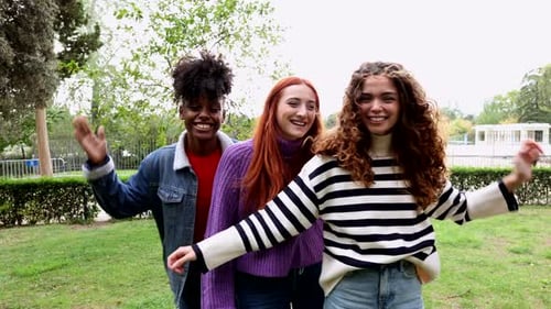 group of three multicultural friends spending a fun afternoon in the park dancing and playing jokes
