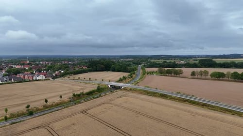 White truck on rural road of American town. Suburb district with harvested wheat fields in summer. A