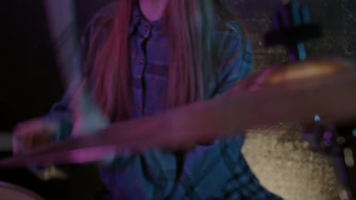Young Person Plays Drum Cymbal in Dark Setting
