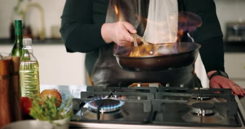Hände, Koch und Feuer mit Pfanne in der Küche zum Kochen mit Zutaten, Zubereitung von Mahlzeiten