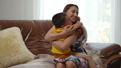Mother and Child Embracing Affectionately on Couch