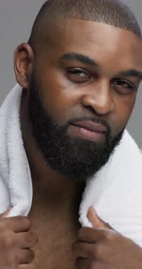 Face, skincare and black man in studio, towel and dermatology on gray background