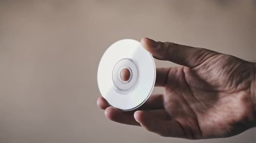 Hand Holding Small Silver Mini Disc