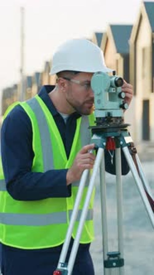 Construction Worker Using Surveying Equipment on Site
