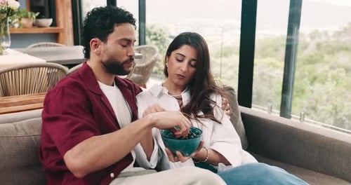 Couple Relaxing on Sofa, Eating Blueberries