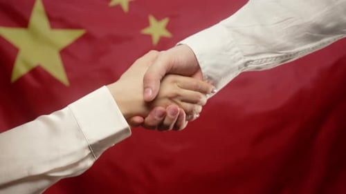 Handshake against flag backdrop