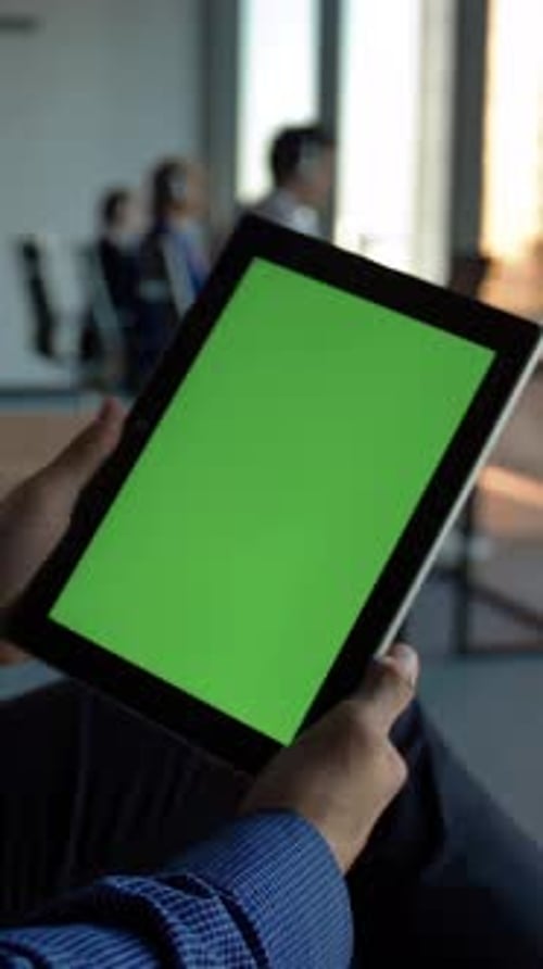 Vertical of Hispanic Entrepreneur Holding a Black Tablet Computer with Green Screen No Faces