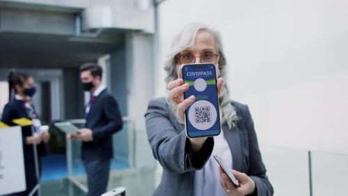 Woman Holds Phone with COVID Pass in Airport