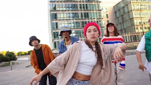 Diverse Young Adults Perform Dance Moves in Urban Setting