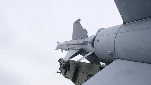 Präzises Bild, das einen modernen Kampfflugzeug mit Raketennutzlast vor bewölktem Himmel zeigt