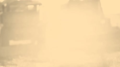 Sepia toned farmer stands beside tractor on farm