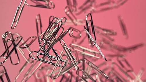 Shiny Silver Paperclips Floating Against Pink Backdrop