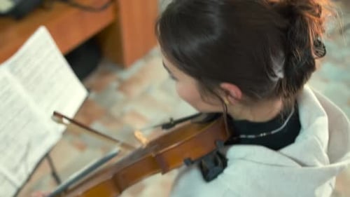 Girl with Dark Hair Plays Violin Indoors