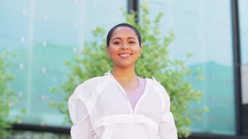Smiling Woman Wearing White Jacket Standing Outdoors