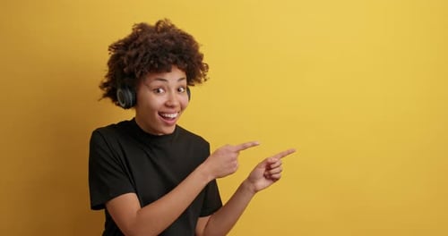 Smiling young woman pointing to copy space