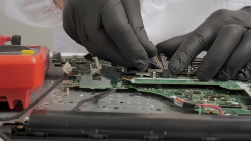 Techniker, der das Speichermodul während der Hardwarereparatur auf der Laptop-Hauptplatine installiert