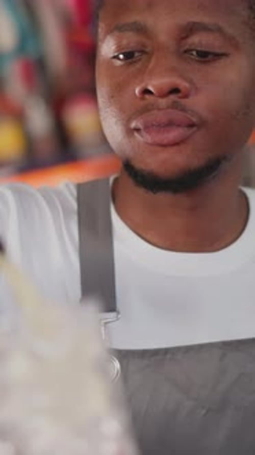 Black Man Pours Cocktail Into Glass with Ice