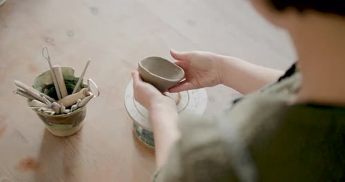 Female Artist Crafting in Pottery studio using Hands and Clay