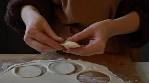 Hands Forming Dumplings at a Table