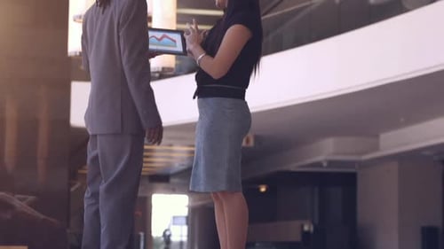 Business Professionals Discussing Data on a Tablet