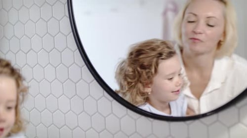 Mother and Daughter in Bathroom Getting Ready