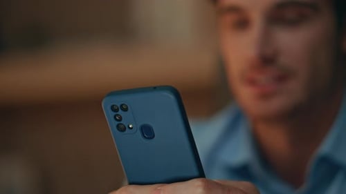 Student Watching Social Media on Cellphone Sitting Evening Apartment Close Up