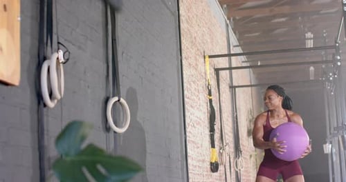 Exercising with medicine ball, woman training in gym for fitness workout, copy space