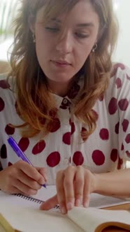 Woman Writing in Notebook Indoors During Daytime