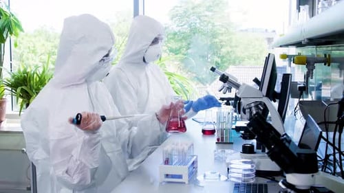 Wissenschaftler in Schutzanzügen und Masken arbeiten im Forschungslabor mit Laborgeräten