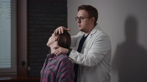 Ein männlicher Osteopath untersucht eine Patientin Der Arzt untersucht Hals und Wirbelsäule