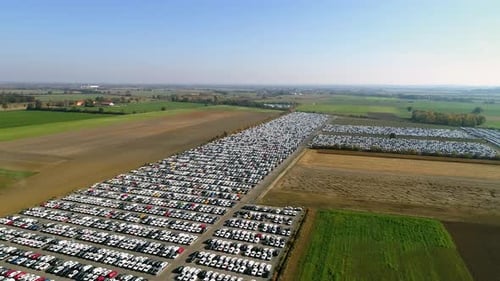 Aerial footage of finished cars ready to be shipped on huge distribution center