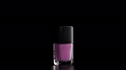 Rotating Purple Nail Polish Against Black Background